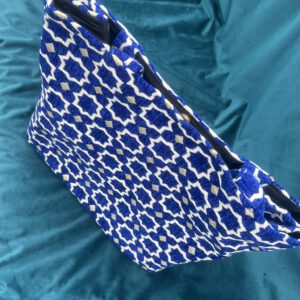 Detailaufnahme des Brokatstoffs der Zahra Royal Tasche: Royaler blauer Hintergrund mit orientalischem Sternmuster in Weiß und Gold, handgewebt in Marokko.
