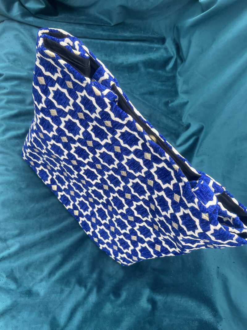 Detailaufnahme des Brokatstoffs der Zahra Royal Tasche: Royaler blauer Hintergrund mit orientalischem Sternmuster in Weiß und Gold, handgewebt in Marokko.