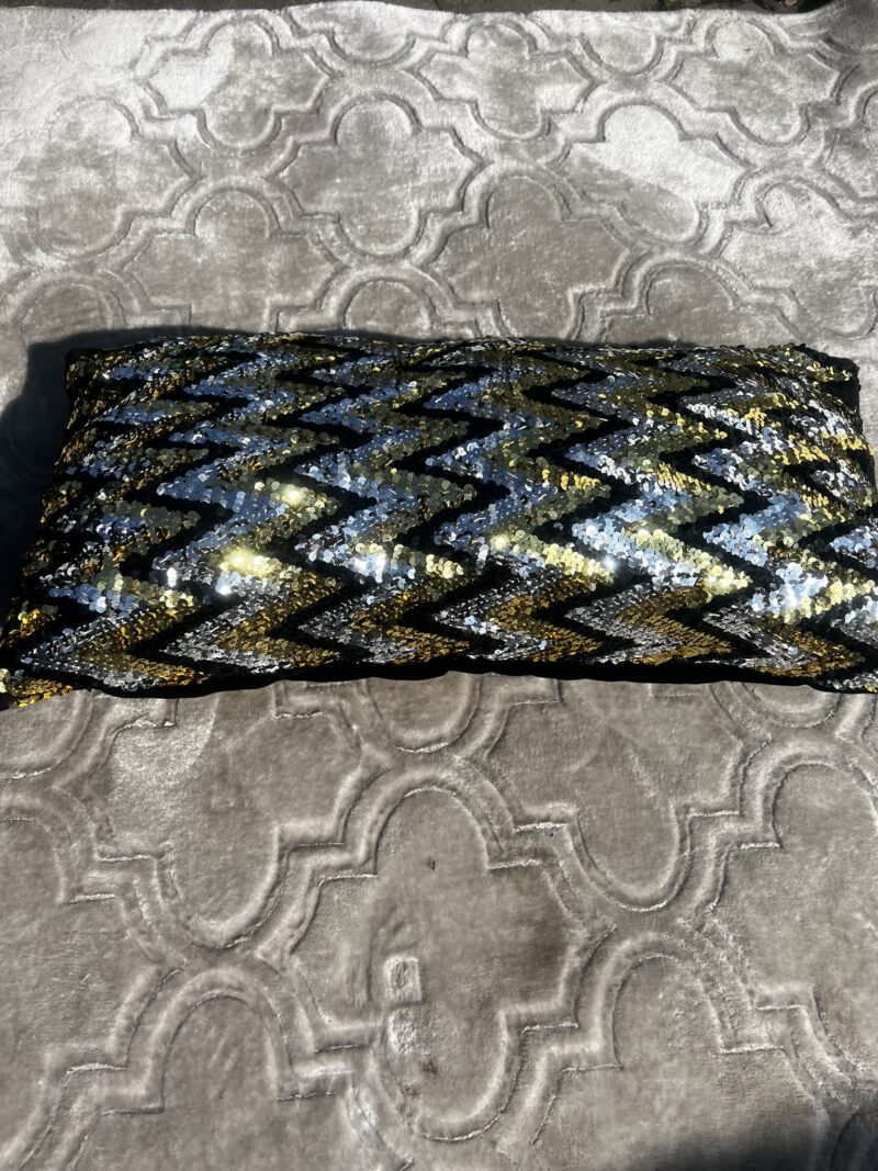 Detailaufnahme eines handgefertigten Kissens mit Pailletten in Schwarz, Gold und Silber – Amani Prima aus Marokko