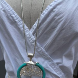 La Vida No. 1 – Silberne Statementkette mit türkisfarbener Umrandung und Lebensbaum-Anhänger, ca. 80 cm lang, ohne Verschluss, getragen