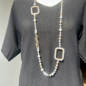 Lange Kette mit lila Glasperlen und goldenen Akzenten, getragen