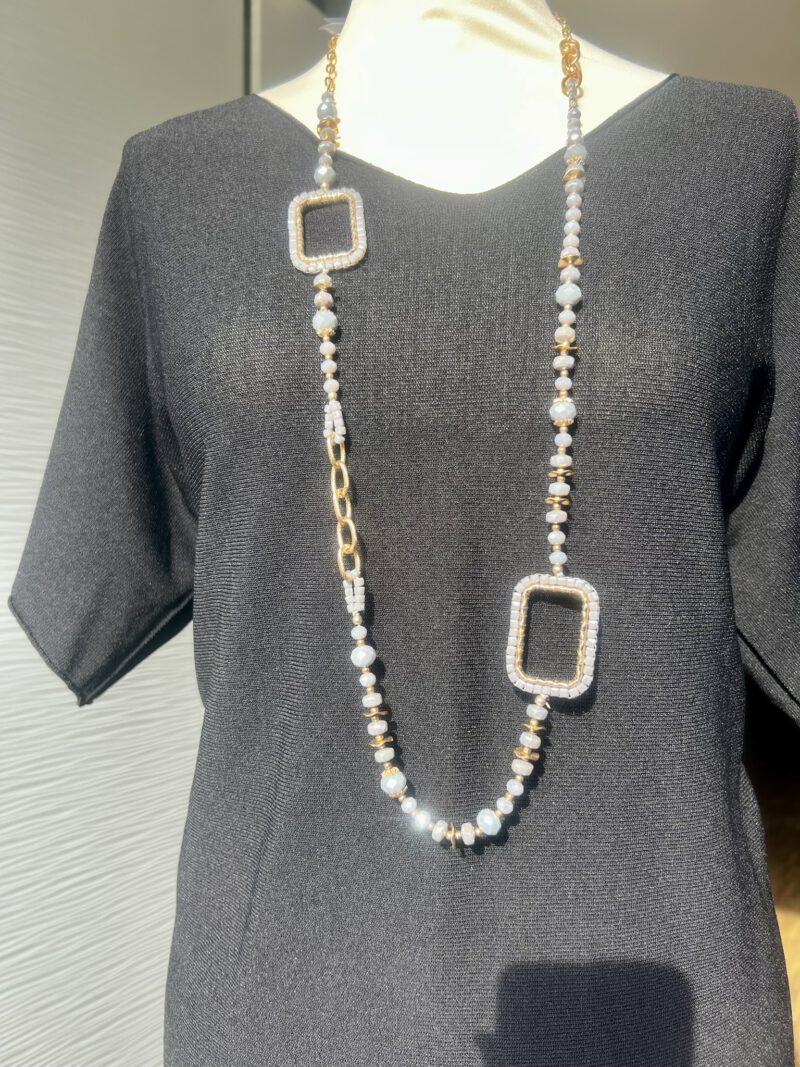 Lange Kette mit lila Glasperlen und goldenen Akzenten, getragen