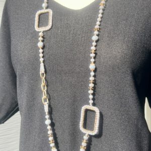 Lange Kette mit lila Glasperlen und goldenen Akzenten, getragen