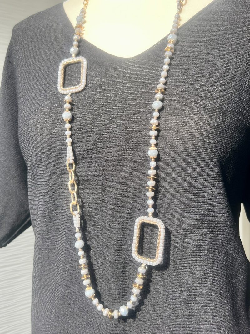 Lange Kette mit lila Glasperlen und goldenen Akzenten, getragen