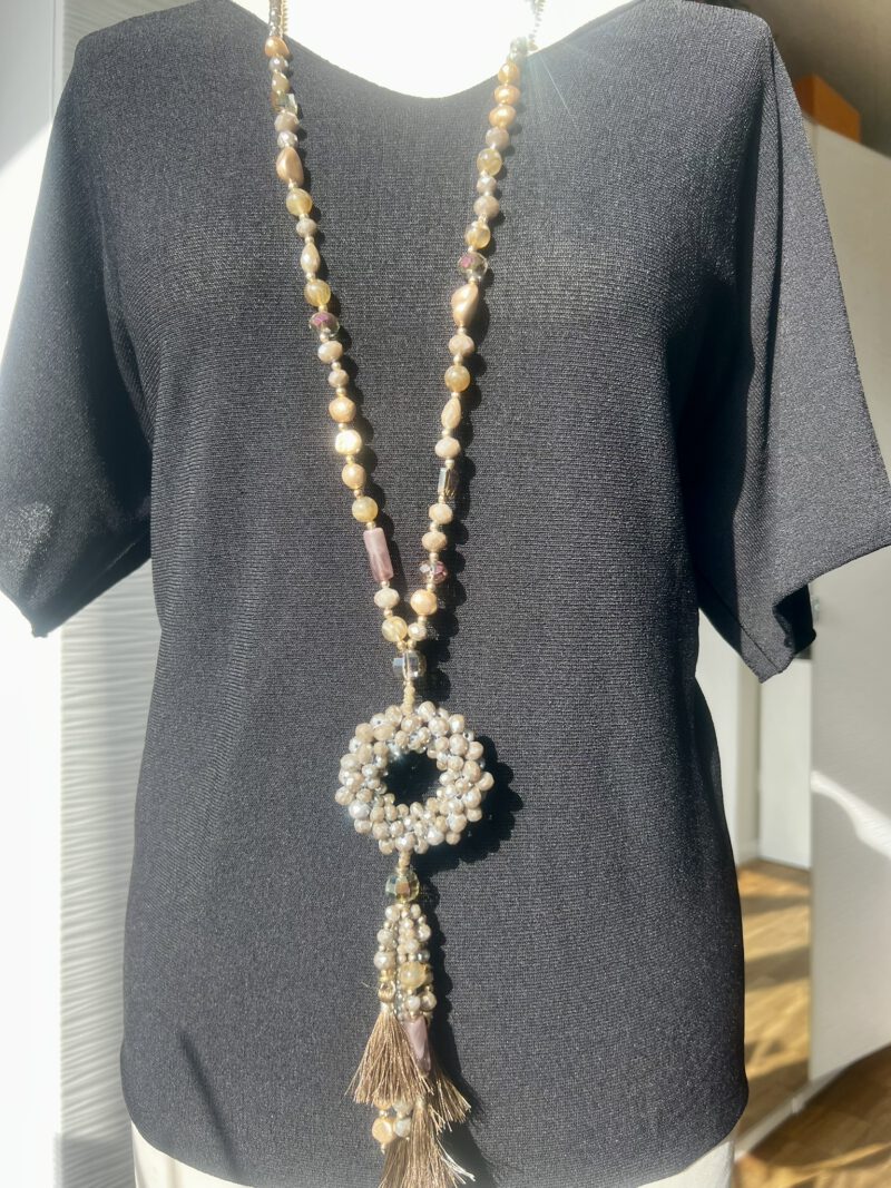 Lange Statement-Kette mit Perlen in Beige und Gold – getragen auf schwarzem Shirt